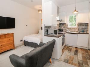 a living room with a kitchen and a bed at Riber in Matlock