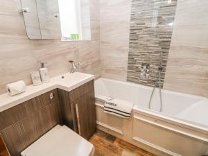 a bathroom with a tub and a toilet and a sink at Riber in Matlock