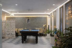 a pool table in the middle of a room at Saffron Inn - Near India Expo Mart in Greater Noida