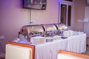 a table with plates and dishes on top of it at Spring Hills Group in Dodoma