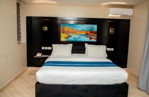 a bedroom with a large bed with a painting on the wall at Spring Hills Group in Dodoma +17 photos