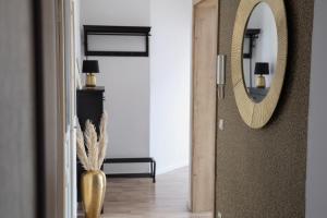 a hallway with a mirror and a vase on the floor at Boutique Suite Hannah in Bautzen