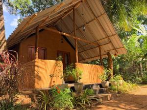 a small house with a straw roof at Mango Tree Villa in Sigiriya +47 photos