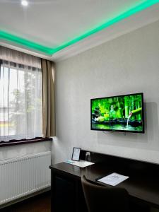 a hotel room with a flat screen tv on the wall at Lotus House in Hermina-major