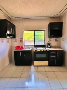 a kitchen with black cabinets and a stove and a window at La prieta linda in Tamasopo