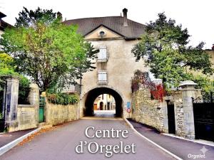 an old house with an archway in a street at La parenthèse Jurassienne in Orgelet