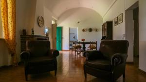 a living room with two chairs and a table at Le Matine di San Teodoro in Stazione di Metaponto +11 photos