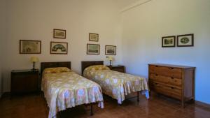 a bedroom with two beds and a wooden dresser at Le Matine di San Teodoro in Stazione di Metaponto