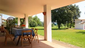 a table and chairs on a patio with a yard at Le Matine di San Teodoro in Stazione di Metaponto