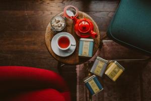 a tray with a cup of tea and a pair of scissors at Ruby Zoe Hotel London by IHG in London