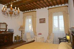 a bedroom with a bed and two windows and a table at Anacleto via Castello 48 in Collodi