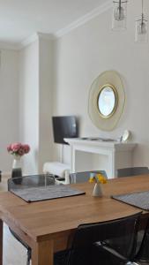 a wooden table with chairs and a mirror in a room at MoMa Homes Kecskemét in Kecskemét +14 photos