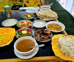 a table topped with plates of food and bowls of soup at Old Oasis Hotel for Safari Trips in Az Zabū