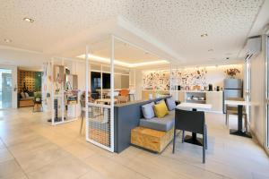 a living room with a couch and a table at Sweetly Isatis Mérignac Hôtel de ville in Mérignac