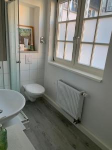 ein Badezimmer mit Toilette, Waschbecken und Fenster in der Unterkunft Ellerbach WG Komfortables Privatzimmer in Bad Kreuznach