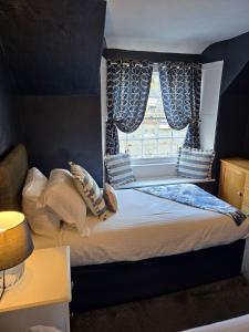 a bedroom with a bed with a window at Harbour Moon Inn in Looe