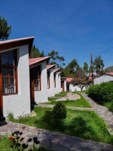a row of white houses with a pathway at Casona Urinsaya Qolca in Chivay