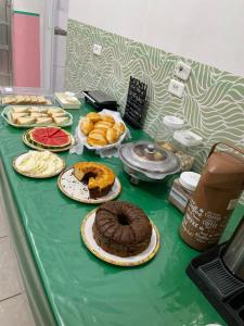 a table topped with different types of cakes and pastries at Pousada Pura Vida Bertioga in Bertioga