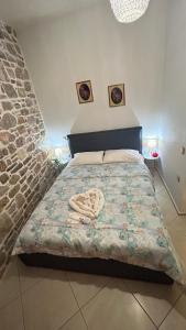 a bedroom with a bed with a stone wall at Petra Home Pyrgi in Pyrgi