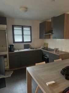 a kitchen with black cabinets and a table in it at Villa de l Eyre in Salles