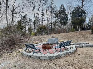 two benches sitting around a fire pit in a field at Bluff Mountain Vista in Sevierville