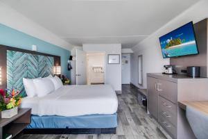 a hotel room with a large bed and a kitchen at Crystal Coast Oceanfront Hotel in Atlantic Beach
