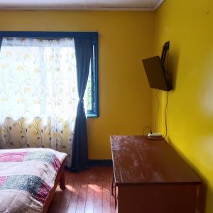 a bedroom with a bed and a window at Hostal Adriana in Valdivia