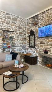 a living room with a couch and a stone wall at Petra Home Pyrgi in Pyrgi