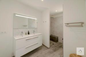 a white bathroom with a sink and a mirror at Ker Lilouane in Hirel +15 photos