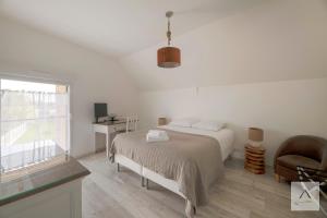 a bedroom with a bed and a chair and a window at Ker Lilouane in Hirel
