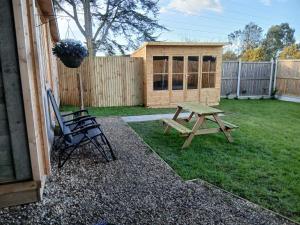 a picnic table and a bench next to a fence at The Homestead Compact With private Lazy spa in Northbourne