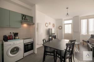 a kitchen and dining room with a table and a washing machine at La Maison de Pêcheurs in Cancale