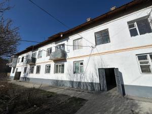 a large white building with a door in front of it at Karakol 'Ethno' Apartment in Karakol