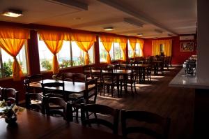 a dining room with tables and chairs and windows at Costa Brava Praia Hotel in Lucena