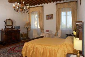 a bedroom with a bed and a dresser and windows at Anacleto via Castello 48 in Collodi