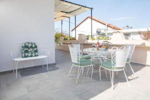 a patio with a table and chairs on a patio at Filerimos House in Ialysos