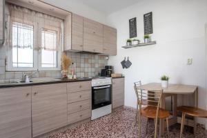 a kitchen with wooden cabinets and a table and a table and chairs at Filerimos House in Ialysos +27 photos