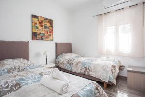 a bedroom with two beds and a window at Filerimos House in Ialysos