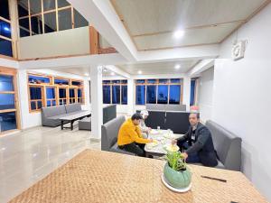 three people sitting at a table in a restaurant at YNL HOMESTAY a boutique hotel in Dirang Dzong