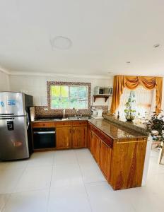 a kitchen with wooden cabinets and a stainless steel refrigerator at Enchanted Paradise in Ayacucho +8 photos