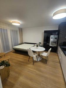 a room with a table and chairs and a bed at 365 apartmány AUPARK in Piešťany