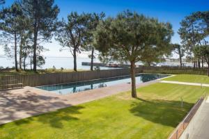 a swimming pool with a tree in a yard at Santi Cabodeiro in Isla de Arosa