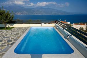 a swimming pool with a view of the water at Thea Hill in Kritharia