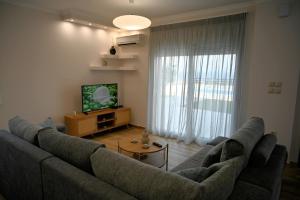 a living room with a large couch and a television at Thea Hill in Kritharia