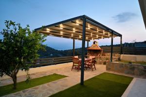 a pergola with a table and chairs on a patio at Thea Hill in Kritharia