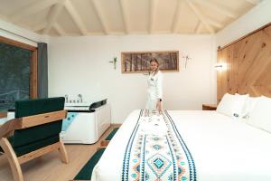 a woman standing on a bed in a room at Tara Vegan Lodge - Sacred Valley in Urubamba