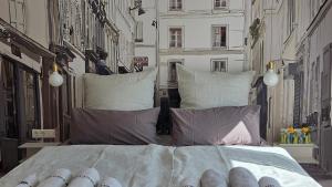 a bedroom with a large bed with pillows at MoMa Homes Kecskemét in Kecskemét