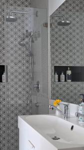 a bathroom with a white sink and a shower at MoMa Homes Kecskemét in Kecskemét