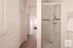a white bathroom with a shower with a glass door at La Cabane à Hirel in Hirel +18 photos