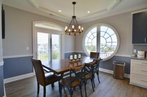 a dining room with a wooden table and chairs at 5 BR Poolside Paradise Just Steps from the Beach in Ocean Isle Beach
